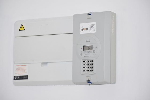 Elektrische meterkast met groepenschakelaars op een witte muur